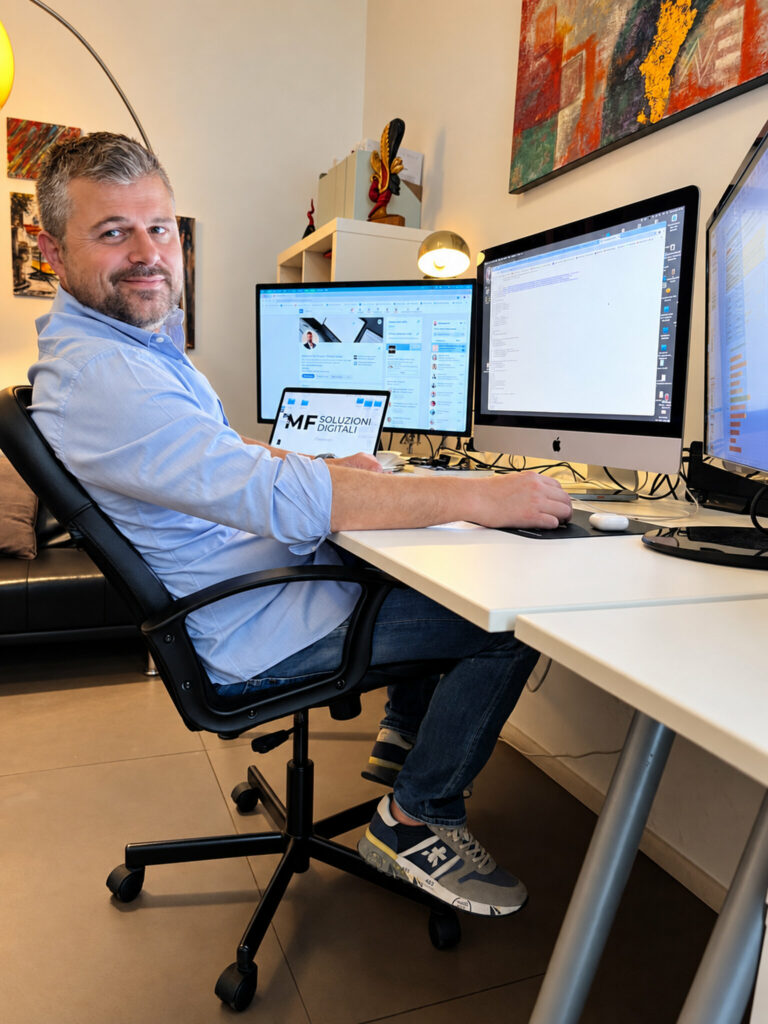 Massimo De Stefano SEO Specialist alla postazione di lavoro con monitor e sito MF Soluzioni Digitali